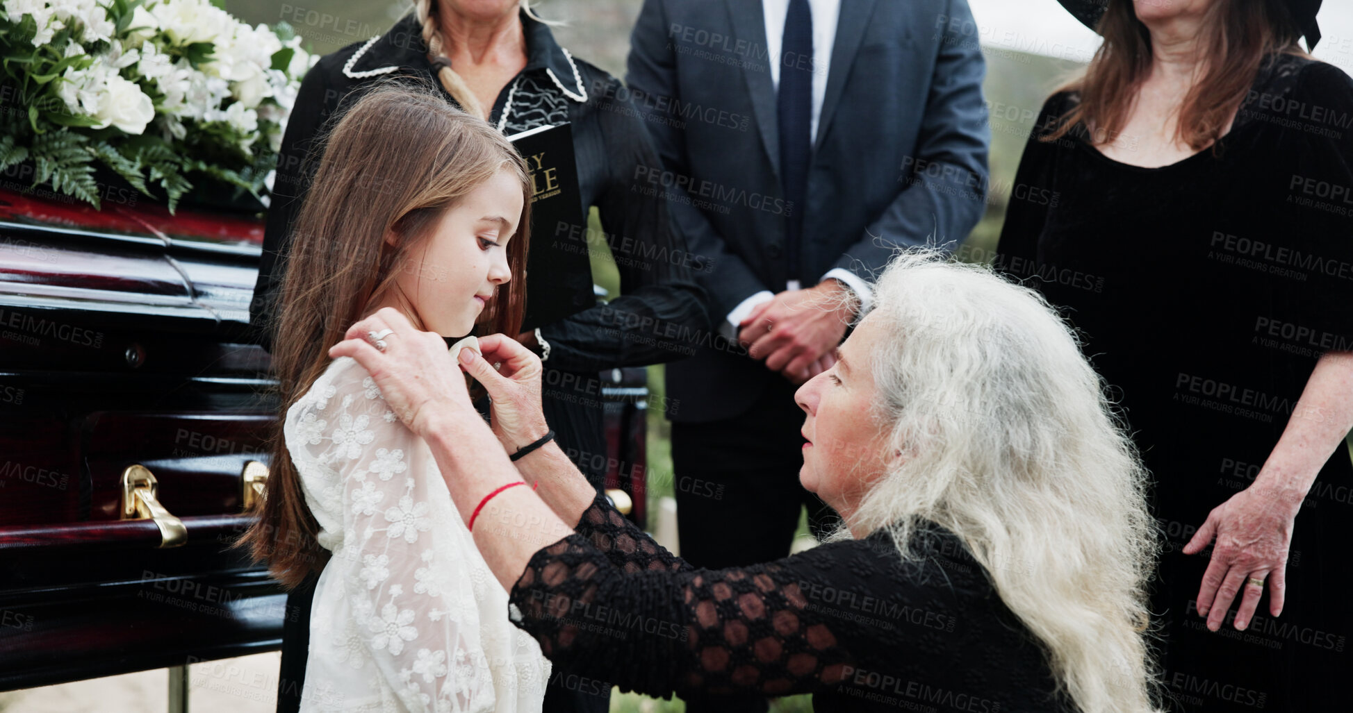 Buy stock photo Sad, grandmother and child in graveyard with funeral, people mourning and support for burial ceremony. Senior woman, girl and family death at cemetery outdoor with memorial service, empathy and care.