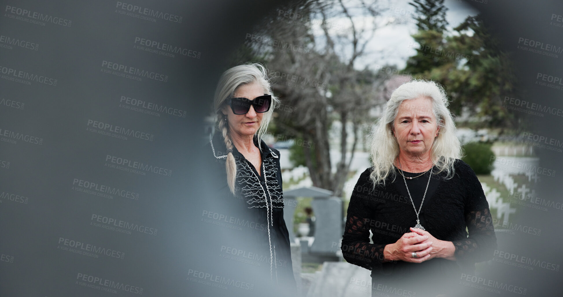 Buy stock photo Sad, funeral and senior women at graveyard with grief, support or loss at burial ceremony with circle space. Family, death and elderly people with mourning at cemetery outdoor at memorial service.
