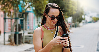 Buy stock photo Woman, sunglasses and typing in city with phone, social media update or notification for text message. Happy, person and shades outdoor in urban town with tech, browsing website or online dating app.