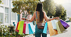 Shopping bag, sale and walking with back of woman in city for black Friday deal, gift and discount. Savings, promotion and boutique product with person outdoor for vip customer and retail therapy