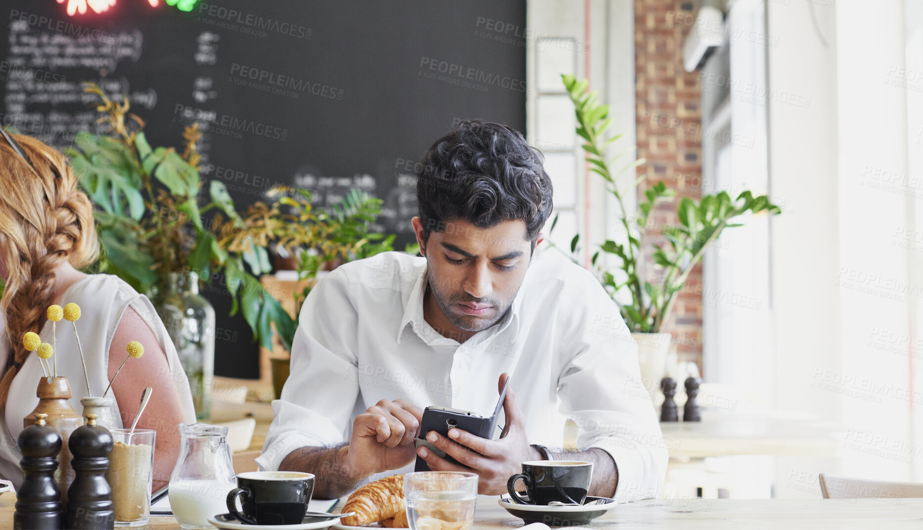 Buy stock photo Phone, relax and man in cafe for online message, text or check social media for communication. Mobile, serious person and customer in coffee shop, internet chat or networking with morning breakfast