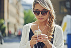 Woman, earphones and music with phone in city for travel, audio app or sound playlist. Female person, traveler or user listening with sunglasses or mobile smartphone for radio podcast in urban town
