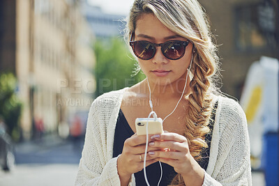 Buy stock photo Woman, earphones and music with phone in city for travel, audio app or sound playlist. Female person, traveler or user listening with sunglasses or mobile smartphone for radio podcast in urban town
