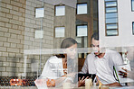 Window, discussion and business people with tablet in cafe for planning creative project together. Technology, review and magazine editor with manager for feedback on publishing in coffee shop.