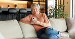Mature, woman and typing on sofa with phone for text message, communication or dating site in home. Happy person, relax and tech for social media, online browsing and check email notification