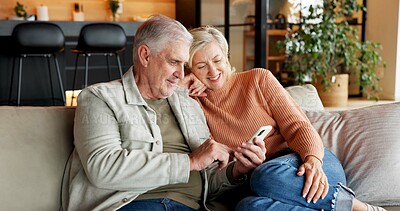 Buy stock photo Laughing, home and senior couple with phone, connection or watching funny movie on website in lounge. Mature people, smile and streaming comedy with partner, online and bonding with mobile in house