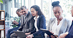 Technology, candidates and business people in waiting room for interview, opportunity or job. Professional group, onboarding and employment or recruitment with laptop for research or questionnaire