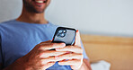 Man, hands and typing with phone in bedroom for network connection, social media or browsing. Male person, communication or texting with smile on mobile smartphone for online chatting app in home