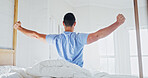 Man, morning and stretching in bedroom for comfort, healthy sleep or recovery in home. Back view, male person or waking up with open arms in bed for beauty nap, well rested or start day in house