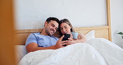 Buy stock photo Happy, relax and couple with phone in bedroom for social media, communication or network connection. Man, woman or chilling with smile or coffee on mobile smartphone for chatting or texting in home
