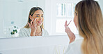 Mirror, skincare and happy woman with cream in bathroom for hydration, skin wellness and beauty. Smile, person and apply facial lotion in morning routine, dermatology benefits or reflection at home