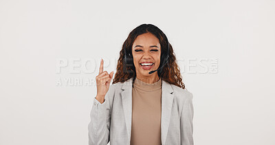 Buy stock photo Portrait, headset and businesswoman by mockup space for advertising of call center in studio. Pointing, mic and female technical support consultant with tips on customer service by white background.