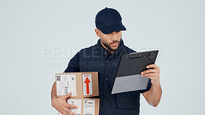 Buy stock photo Delivery man, boxes and reading on tablet in studio for shipping info, dropshipping and courier service. Online schedule, check customer details or person with tech and package supplier on background