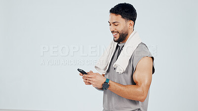 Buy stock photo Happy, man and phone in studio for fitness app, social media notification and satisfied with workout. Mockup space, active person and typing with tech, search exercise and smile for wellness update.