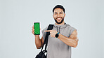 Green screen, phone and portrait of bodybuilder in studio with space for gym subscription. Happy, man and athlete pointing to cellphone for fitness app, website or blog on tech by white background.