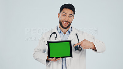 Buy stock photo Doctor, portrait or happy man pointing with tablet or green screen in studio for Telehealth app. Male person, healthcare worker or technology with mockup space for advertising on a white background