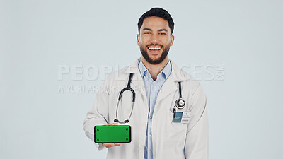 Buy stock photo Green screen, man and portrait of doctor with cellphone in studio for clinic sign up, FAQ and telehealth. Phone, space and healthcare worker on mobile app for medical information by white background.
