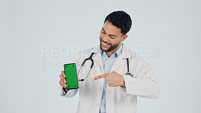 Buy stock photo Green screen, pointing and doctor with phone in studio for clinic sign up, FAQ and telehealth. Cellphone, man and healthcare worker on app for medical information by white background with space.
