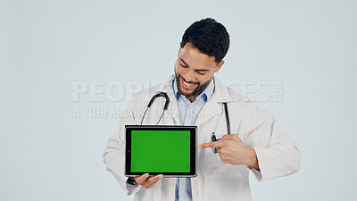 Buy stock photo Doctor, pointing or happy man with tablet green screen in studio for Telehealth app or marketing. Male person, healthcare worker or smile with technology display for advertising on a white background