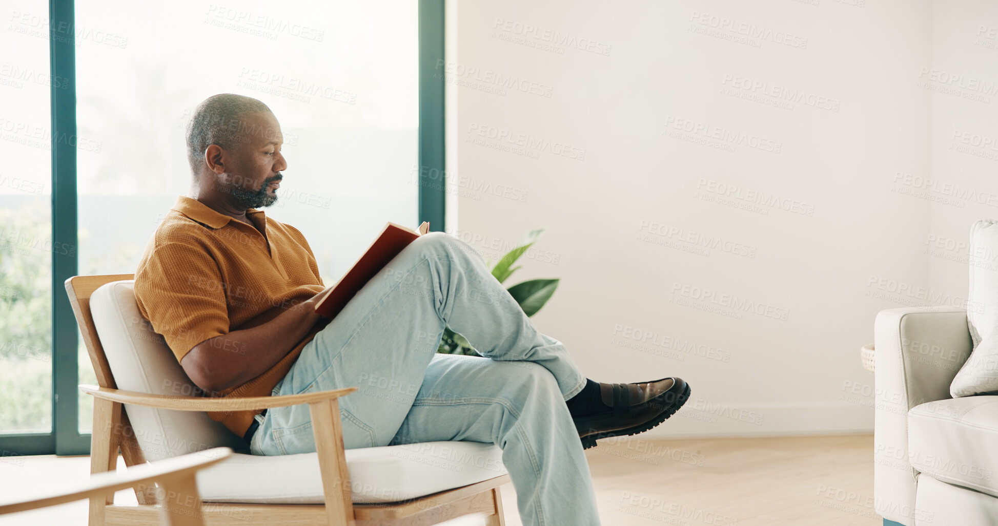 Buy stock photo Reading, relax and weekend with black man on chair in home living room for break or hobby. Novel, space and story book with mature person in apartment for literature, me time or tale of fiction