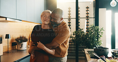 Buy stock photo Happy, hug and couple in kitchen for cooking, bonding and love with music, song and meal prep. Interracial, marriage and mature man and woman dancing together for dinner, lunch and embrace in home