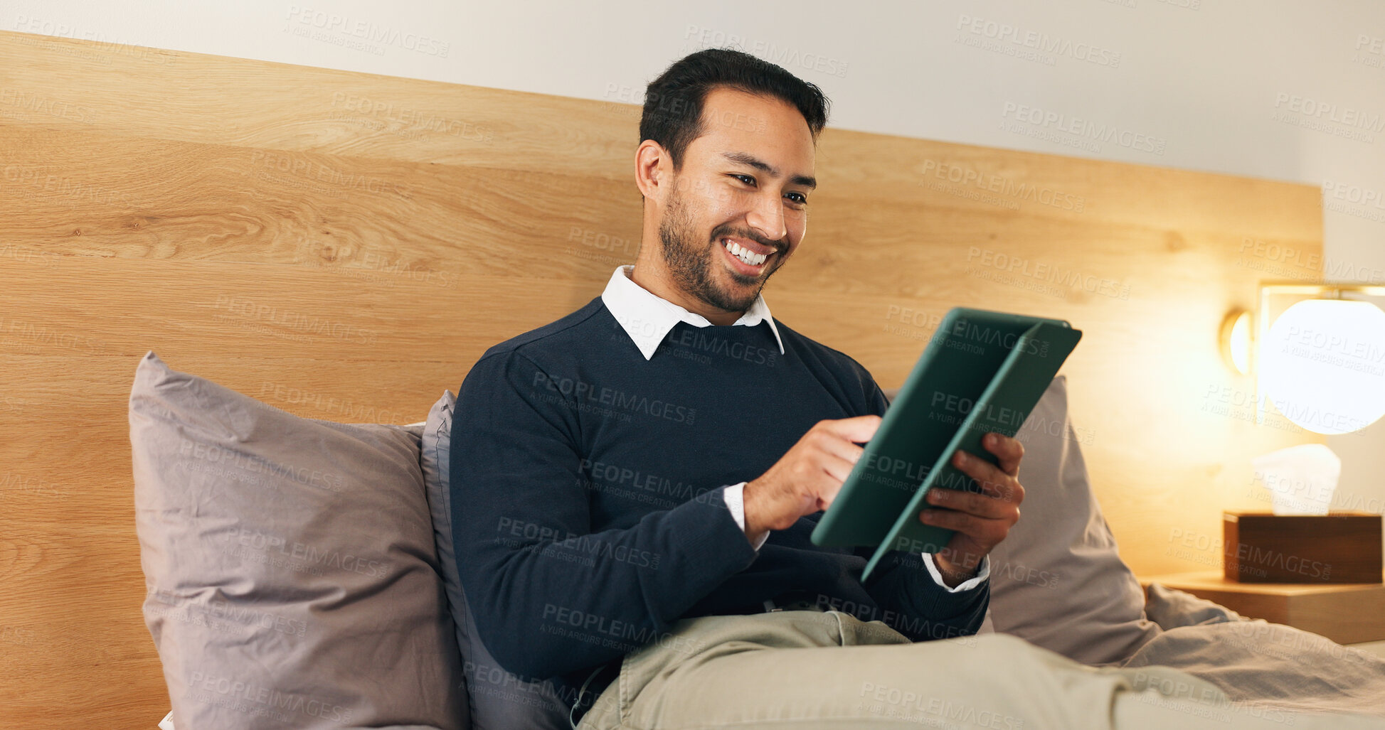 Buy stock photo Smile, man and relax in bedroom with tablet, social media and browsing website to unwind. Happy, male person and comfortable at house with tech, streaming movies and watching video for weekend break