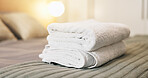 Hotel, empty and towels on bed for accommodation, housekeeping and hygiene at luxury resort. Hospitality, space and bedroom with pillows, duvet and fresh linen for comfort, cleaning and wellness
