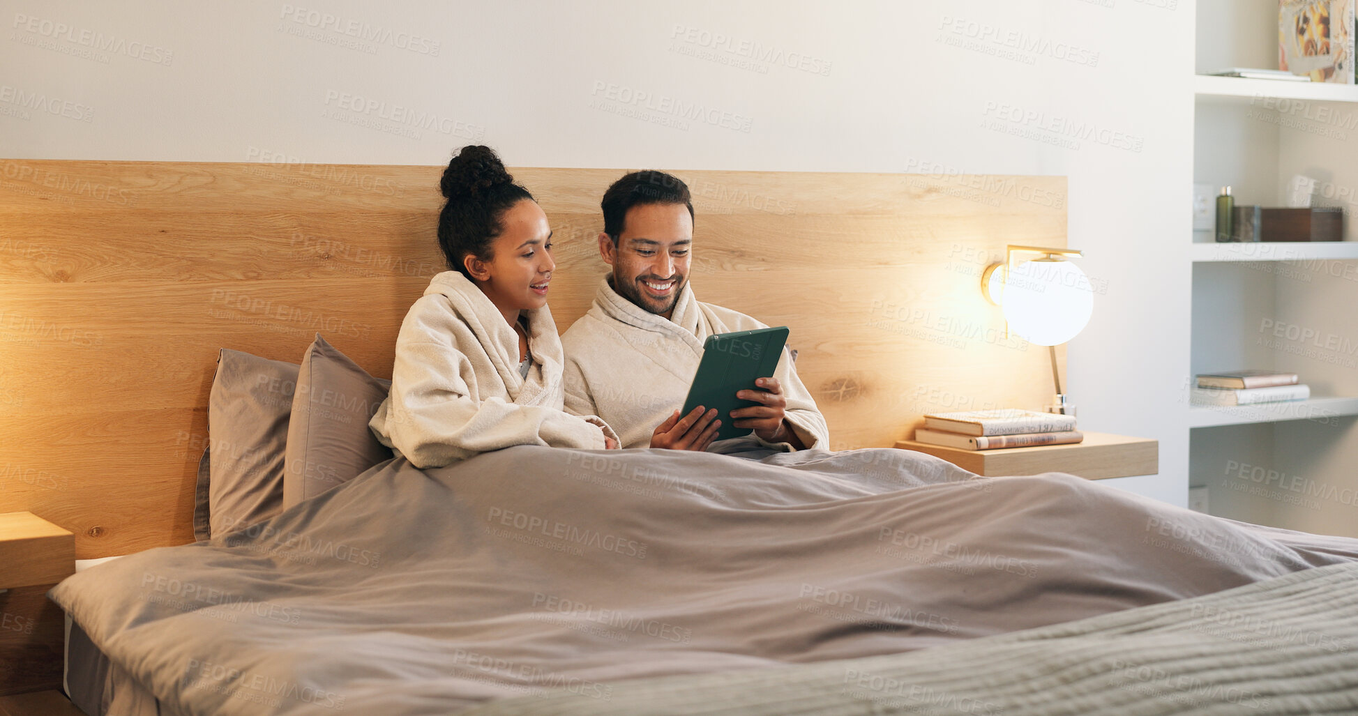 Buy stock photo Happy couple, bonding and relax with tablet in bedroom, entertainment and streaming movie on website. Watching, film and people with technology, internet connection and rest with partner in house