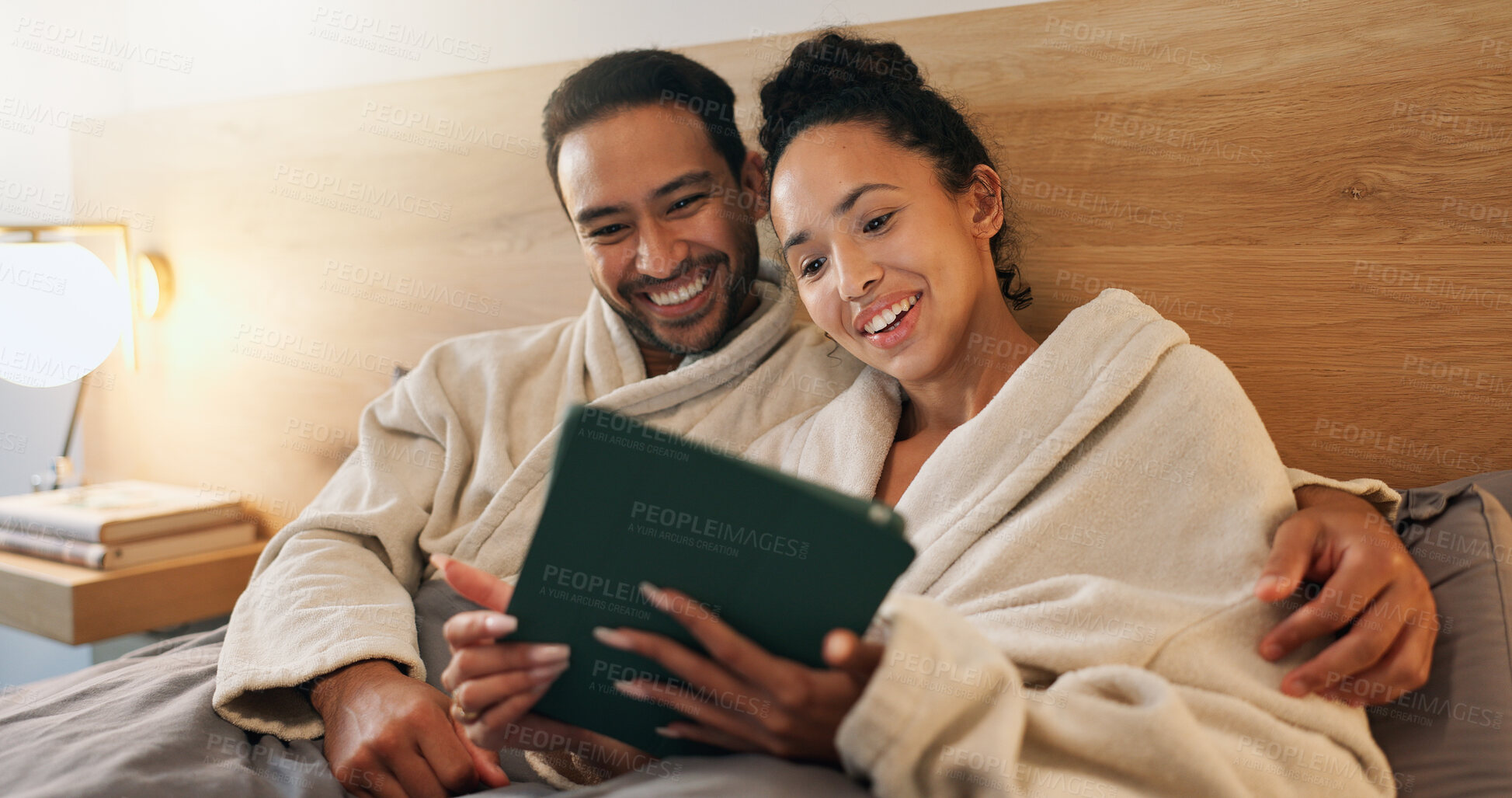 Buy stock photo Couple, chilling and laughing with tablet in bedroom, entertainment and funny movies on social media. Streaming, comedy and happy people with tech, internet connection or embrace with partner in home