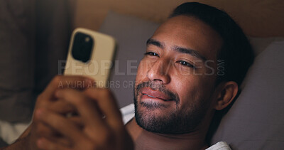 Buy stock photo Reading, message and man with phone in bedroom, biting lip or communication on social media at night. Evening, chat and happy person with mobile, networking and online dating with tech in house