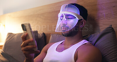 Buy stock photo Phone, bed and man in LED mask, research and browsing website for light therapy benefits. Male person, skincare and cosmetics at house with facial tech, beauty tips and mobile app for acne treatment