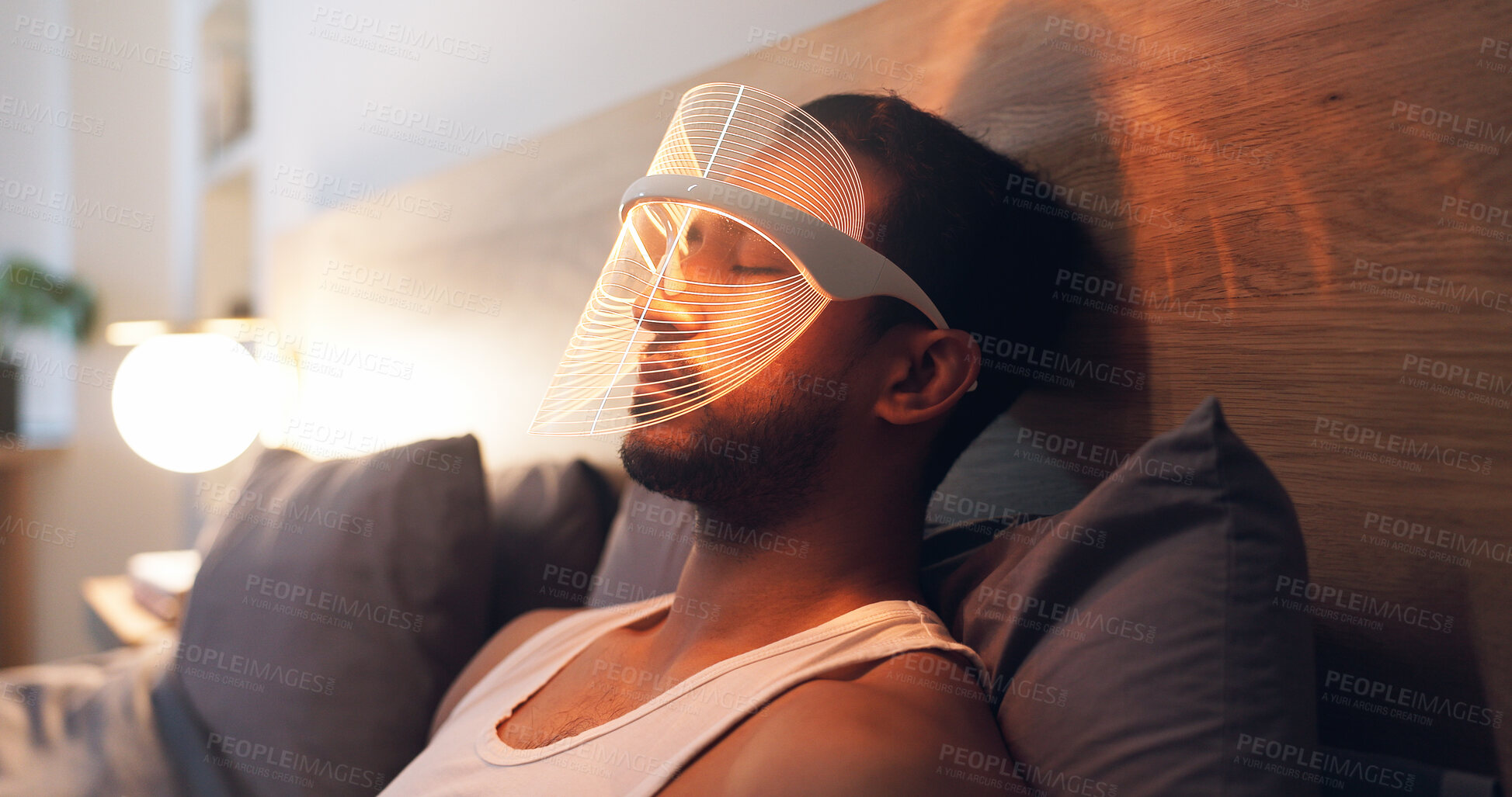 Buy stock photo Man, relax and light with uv mask in bed for facial, skincare or anti aging treatment in home. Beauty, male person or red LED cosmetics for skin protection, collagen or blood circulation in bedroom