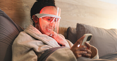 Buy stock photo Red light, dermatology and woman with phone in bed for beauty, wellness and collagen production. Health, relax and person in bedroom with LED phototherapy tech for skincare or mask treatment in home