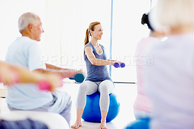 Buy stock photo Dumbbells, exercise and senior people with personal trainer in studio for health or wellness. Fitness class, retirement and weights with instructor at gym for coaching, physical activity or training