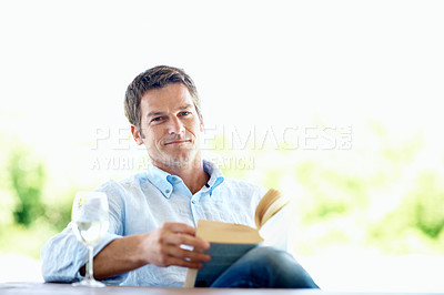 Buy stock photo Portrait, man and wine glass on patio with book, peace and calm morning at holiday resort. Smile, person or space on terrace with novel, champagne or weekend break at luxury accommodation on vacation