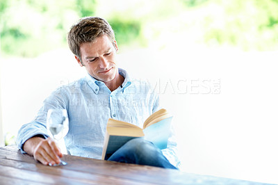 Buy stock photo Reading, book and happy man with wine glass, chill and learning with novel and literature on weekend. Fiction, reader and person with alcohol on break, smile and relax with story or entertainment