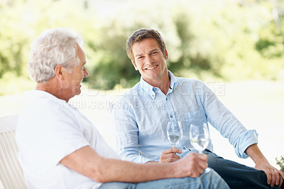 Buy stock photo Wine, backyard and man with senior father for bonding, conversation and relax on weekend. Family, outdoor and person with elderly parent, alcohol and drink for connection, relationship and talking
