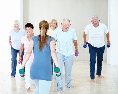 Buy stock photo Dumbbells, class and woman with senior people for exercise, wellness and stretching for mobility. Retirement, gym and trainer with elderly group with weights for health, muscle strength and fitness