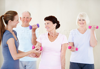 Buy stock photo Pilates, instructor and elderly people in class with dumbbells, support and fitness in retirement. Senior group, trainer and weights at facility for teaching, muscle development or smile for exercise