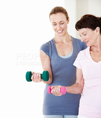 Buy stock photo Dumbbells, fitness and senior woman with personal trainer in studio for health or wellness. Exercise class, retirement and weights with instructor in training space for coaching or physical activity