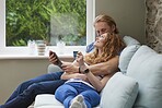 A couple relaxing on the couch together using a credit card to make online purchases