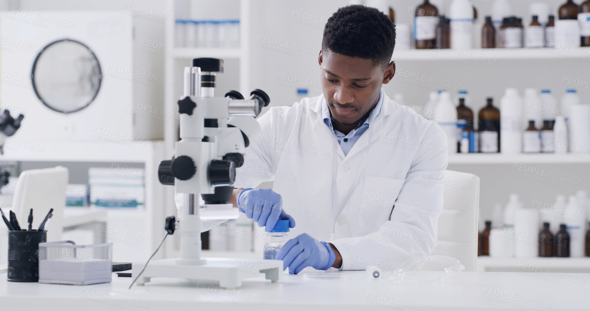 Buy stock photo Microscope, black man and scientist in laboratory with medical research for vaccine innovation. Glass vial, person and chemist with liquid solution for pharmaceutical development with clinic results.