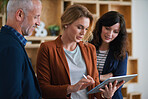 Business people using tablet in office team leader woman meeting with colleagues showing ideas on mobile device screen