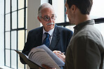 Senior businessman talking to colleague boss mentoring sharing business experience holding documents in office