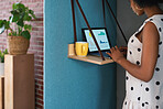 African american business woman using laptop computer in office cubicle with financial graph information on screen