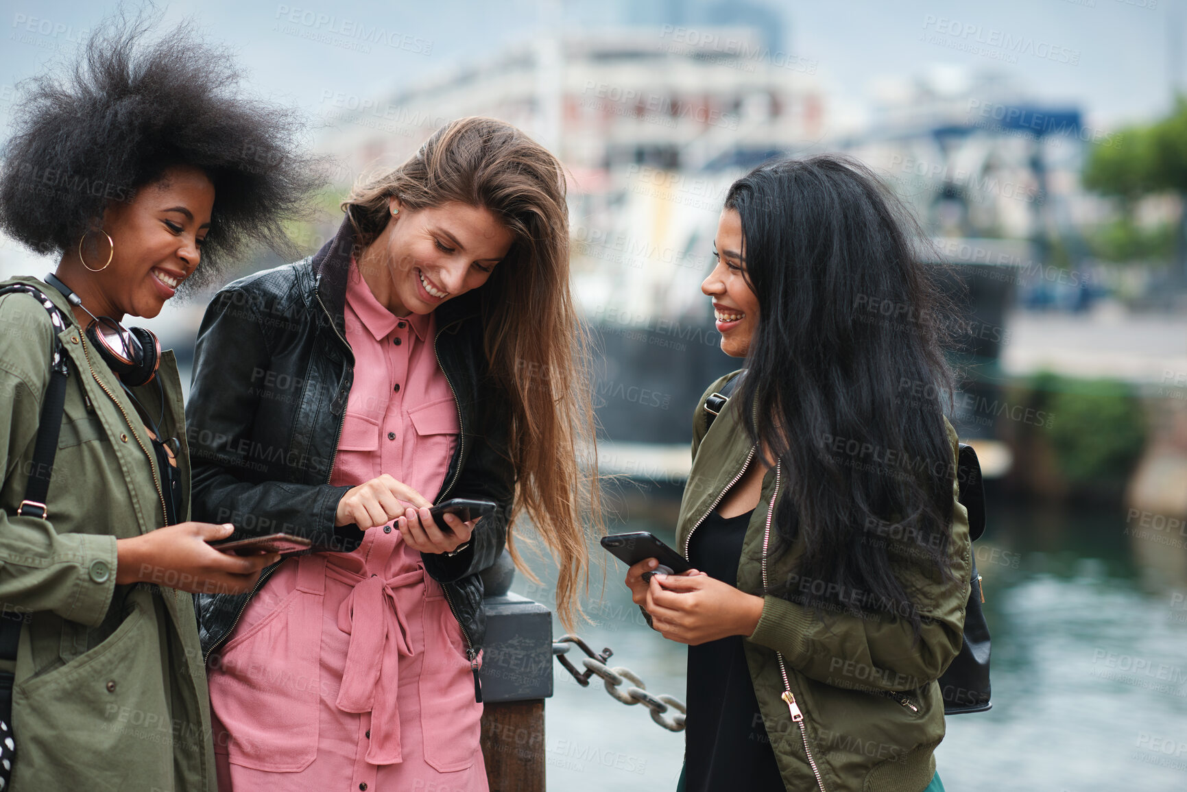 Buy stock photo Hangout, phone and smile of women on promenade together for bonding, connection or typing. App, social media and text message with girl friends outdoor by ocean for browsing, response or reunion