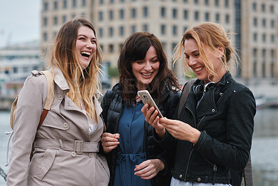 Buy stock photo Funny, hangout and phone with women on promenade together for bonding, connection or typing. App, social media and text message with happy friends outdoor at ocean for browsing, laughing or reunion