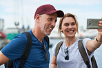 Travel couple taking photo using spartphone in harbour watefront sharing vacation photographing holiday memories with mobile phone camera