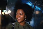 Beautiful african american woman smiling under umbrella enjoying shelter from rainy weather in city evening