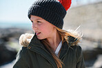 Portrait little girl smiling happy on seaside dressed warm wearing beanie hat and coat
